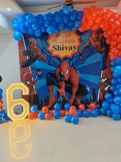 This is a complete Spider-Man theme I created for a 6th birthday. The setup includes a custom backdrop with the birthday boy's name, a large illuminated number '6', character cutouts, and a balloon arch in signature red and blue.
