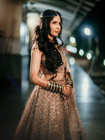 A stunning night-time portrait of this bride in her shimmering gold lehenga, her makeup looking glamorous and chic.