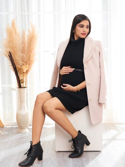 This shot showcases a full view of a chic, modern maternity outfit, proving that you can be both pregnant and fashion-forward.