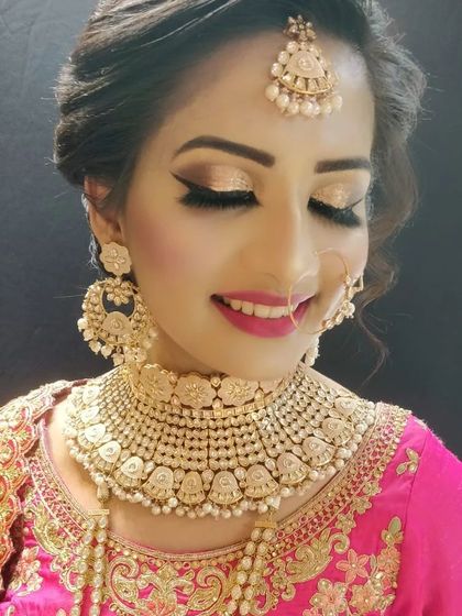 A close-up of a beautiful pearl and gold-toned Kundan choker, paired with a pink embroidered blouse. You can rent individual jewellery pieces or a full set to match your outfit.