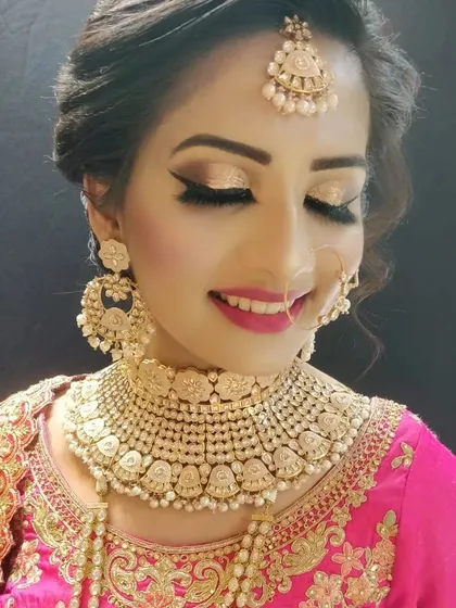A close-up of a beautiful pearl and gold-toned Kundan choker, paired with a pink embroidered blouse. You can rent individual jewellery pieces or a full set to match your outfit.