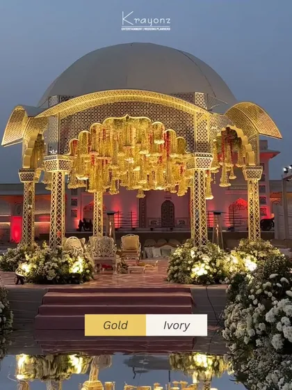 The elegance of gold and ivory comes together in this regal mandap design. The intricate lattice work and hanging floral chandeliers create a space that is both traditional and timelessly luxurious.