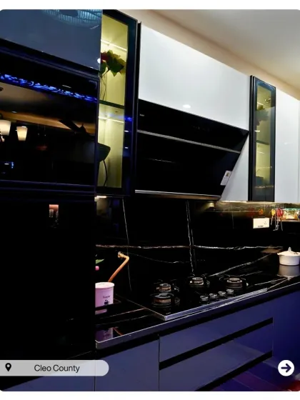 A bold and dramatic kitchen with glossy black and blue cabinets. The design is ultra-modern and perfect for someone who loves a high-contrast look.