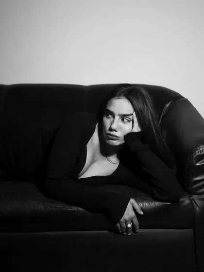 A studio session with a model in a black dress, showcasing a range of poses from pensive to powerful. The lighting is controlled to sculpt the subject and create a sophisticated mood.