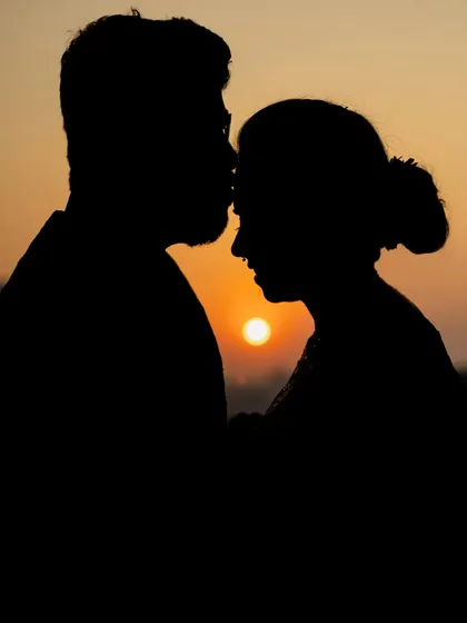 A beautiful sunset silhouette of a couple. This artistic shot is perfect for any couple wanting to capture a romantic, timeless portrait.