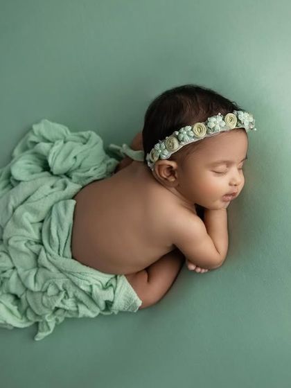 A top down view of the 'taco' pose, with a soft green wrap draped elegantly.