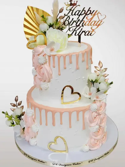 A beautiful two-tier birthday cake with a rose gold drip and delicate floral arrangements. This design is also perfect for an elegant anniversary or engagement party.