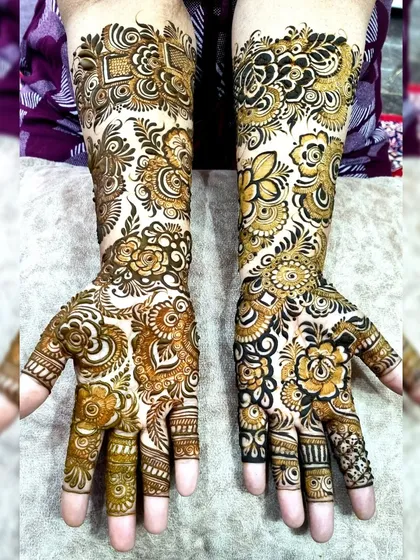 This is a perfect example of an Indo-Arabic floral design. It combines the bold, shaded flowers of Arabic style with the intricate, fine-line fillers of traditional Indian mehndi.