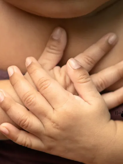 A detail shot focusing on a newborn's tiny hands, gently clasped together. It's a simple yet profound reminder of how small they once were.