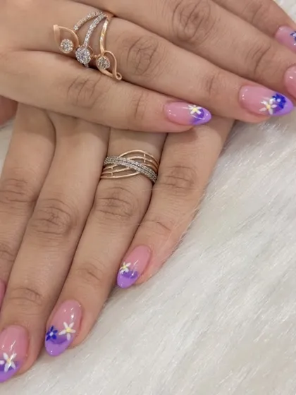 Soft, dreamy, and perfect for any occasion. This design features a gentle purple ombré fade on almond-shaped extensions, finished with tiny, hand-painted white and yellow flowers.
