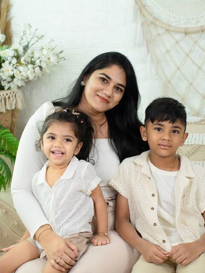 A sweet moment between a mother and her two children. The natural, light-filled studio setting provides a perfect backdrop for these candid family photos.