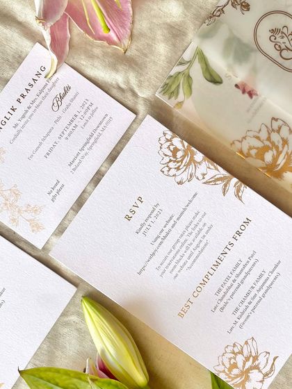 A flatlay of the modern floral suite, showing the RSVP card and the vellum sleeve with a printed floral pattern. Using vellum adds a layer of softness and luxury to the invitation set.