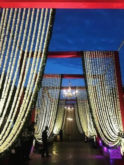 A dramatic entrance against the evening sky, with curtains of white tuberose (rajnigandha) creating a fragrant and beautiful walkway.