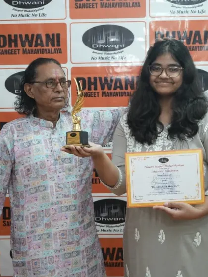 A senior guru presents an award to a deserving student.