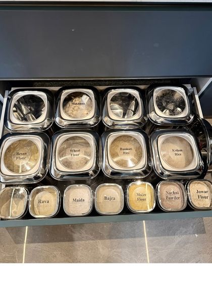 This drawer contains a complete assortment of Indian flours, each in a labeled steel container. This durable and stylish solution is perfect for keeping flours fresh and organized.