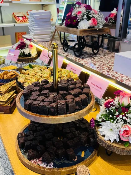 This shot highlights the abundance and variety of our catering. From the tiered brownie platter to the savory bites and floral arrangements, we create a feast for the eyes as well as the palate.