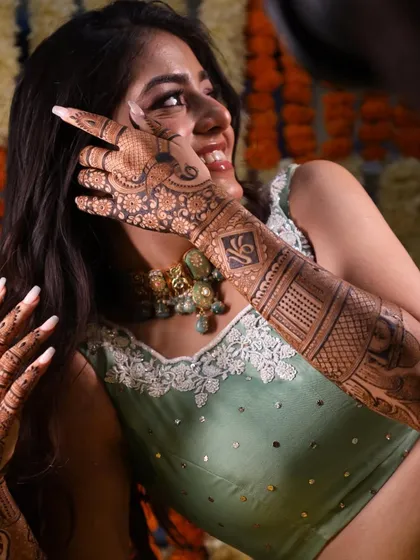 A beautiful bride, her smile and mehandi shining bright. It's a joy to collaborate with talented makeup artists to create the perfect bridal look.