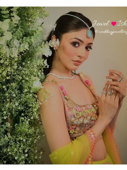 A beautiful shot surrounded by flowers. The simple diamond necklace and turquoise sheeshpatti add a touch of bohemian chic to this colourful pre-wedding look.