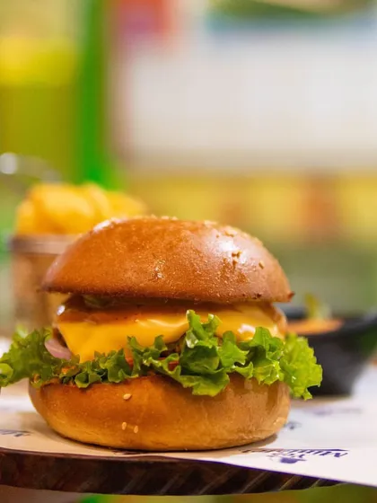 A close-up of our juicy and cheesy gourmet burger. We use high-quality ingredients to create food that parents can feel good about and kids will devour.