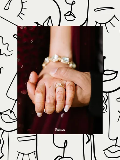 A creative shot of the couple holding hands, framed by modern line art. This image focuses on their connection amidst the energy of the reception party.