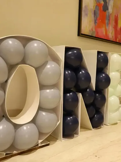 A custom "ONE" balloon mosaic structure. This is a popular and eye-catching decor piece for first birthday parties that can be customized with any balloon colors.