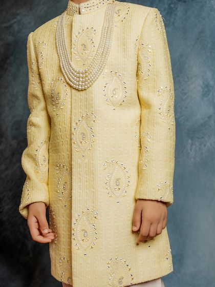 A close-up of the fine embroidery and pearl necklace on our pale yellow sherwani. It’s these luxurious details that make our occasion wear truly special.