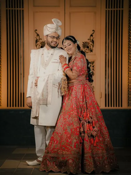 A classic and elegant portrait of a couple in their wedding attire, posed against a beautifully ornate door for a touch of royalty.