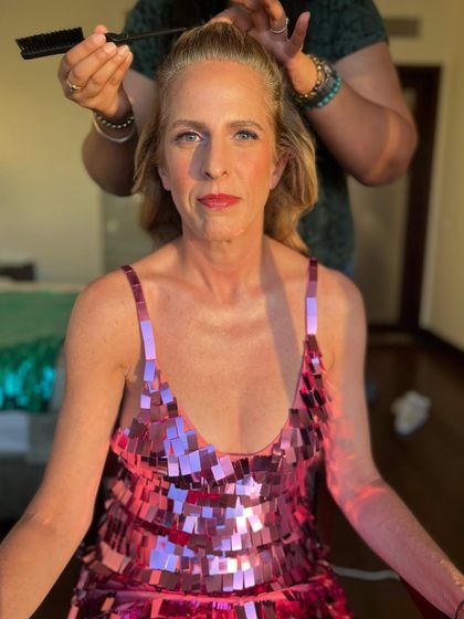 A behind-the-scenes moment during hair and makeup. Even in process, you can see the fresh, glowing skin and the beautiful pink lip color.