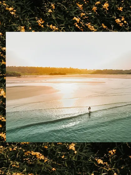 An epic aerial drone shot of a couple alone on a vast, beautiful beach at sunset. This perspective adds a grand, cinematic scale to their love story, showing them against the beauty of nature.