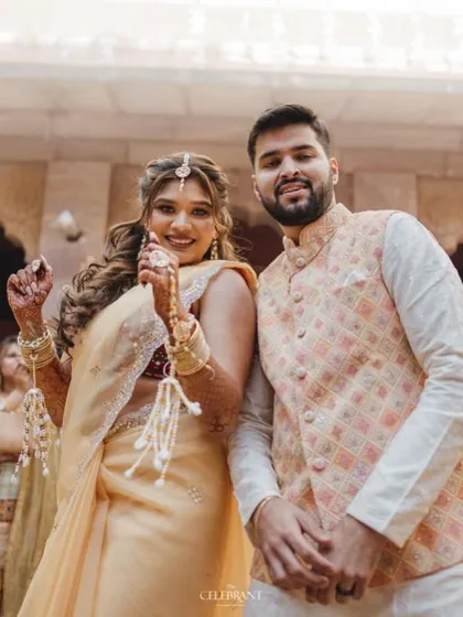 A happy couple posing, with the bride showing off her floral hathphool.