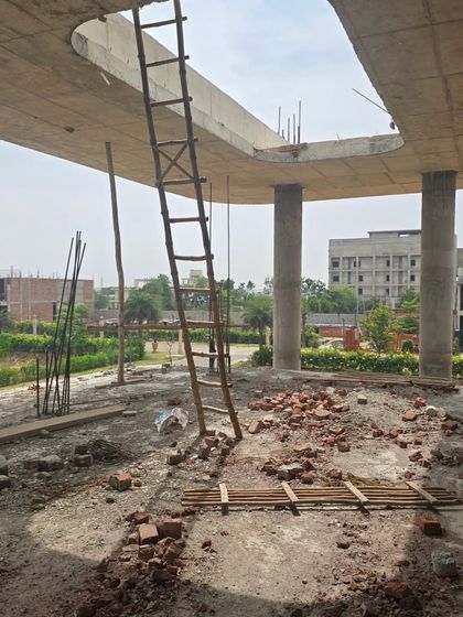A work-in-progress shot from a site in Ludhiana, showing the raw concrete structure with its distinctive curved slab edges. This image captures the beauty of the building's form even during the early stages of construction.