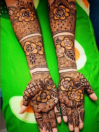 A full-coverage floral mehandi design that is both bold and beautiful. The repeating rose motifs from the palm to the forearm create a cohesive and eye-catching look, ideal for festivals and parties.