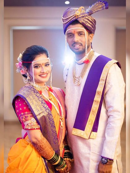 A picture-perfect moment for this adorable Marathi couple. The bride, Trupti, is radiant in her yellow Nauvari saree, with traditional makeup and a floral-adorned bun.