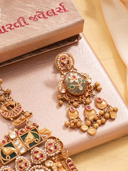 The exquisite earrings from our Maharani Haar set. Each one is a miniature masterpiece, echoing the grandeur of the necklace with its intricate enamel work and dangling gold beads.
