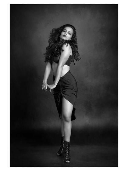 A dynamic black and white portrait of a dancer in motion. The image captures the energy and passion of her performance.