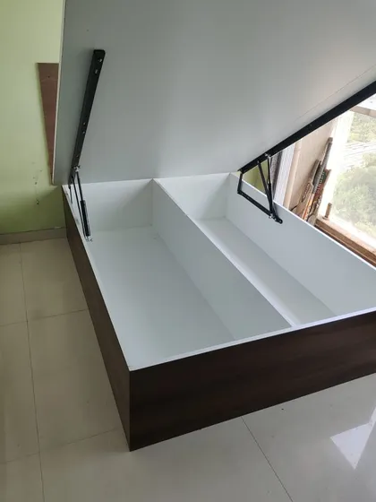 A bed with a hydraulic lift system, shown open to reveal the spacious storage compartments inside. This is a key feature I recommend for maximizing storage in Mumbai apartments.