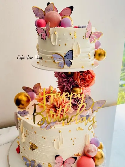 A floating two-tier cake decorated with butterflies and flowers, creating a stunning and whimsical effect.