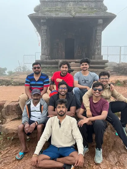 A group of friends poses at a historic temple site during a trek. Our trips often blend nature with culture, offering a rich and diverse experience.