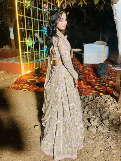 A back view of the beige and purple lehenga, showing the low-back blouse design.
