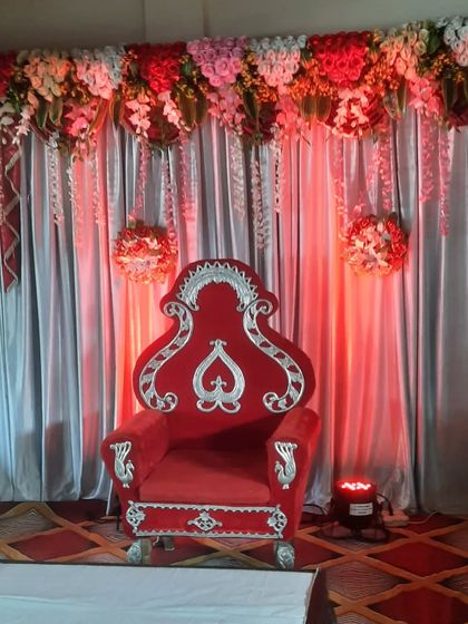 A single, throne-style red velvet chair. This is perfect for a birthday boy or girl, or for a 'dohale jevan' (baby shower) ceremony.