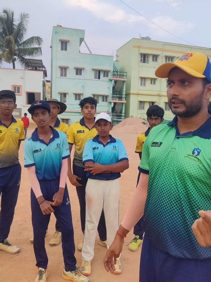 A coach giving instructions to a group of senior players. Our coaching adapts to the needs of different age groups and skill levels.