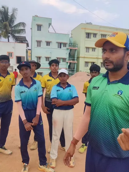 A coach giving instructions to a group of senior players. Our coaching adapts to the needs of different age groups and skill levels.