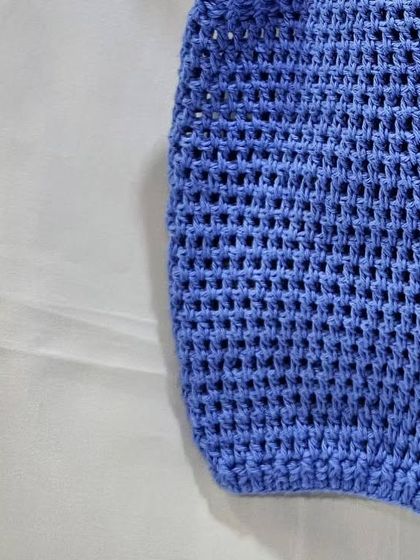 A close-up of the mesh-like stitch I used for this baby romper. The open weave makes it breathable and lightweight, perfect for a baby's delicate skin.