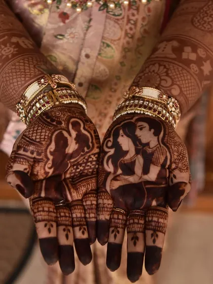 A close-up of the parent-to-be portraits from the baby shower mehendi. The stain is developing beautifully, highlighting the silhouettes.