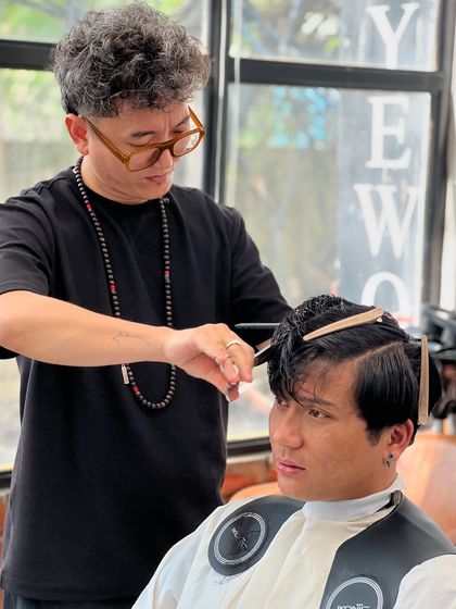 A close-up of our lead stylist's precise scissor work during a men's haircut.