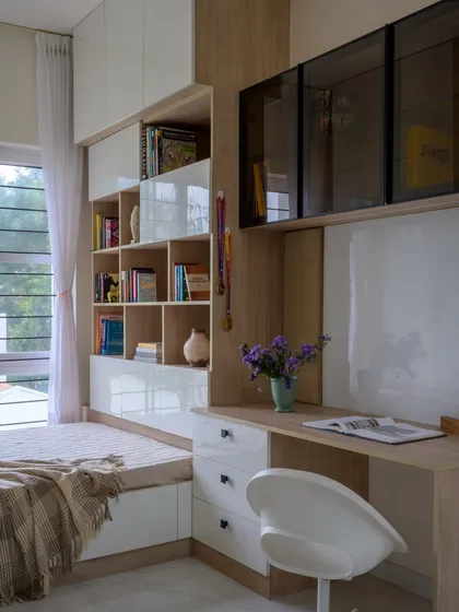 This multi-functional nook was designed for a family of book lovers. It serves as a cozy reading spot, a study desk, and a family zone, with optimized shelving and bright, glossy surfaces to keep the space feeling airy.