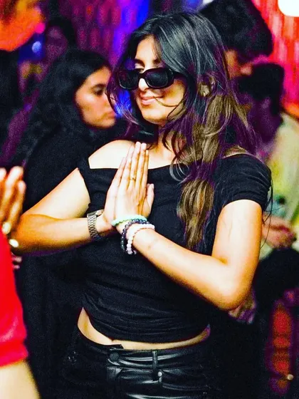 A partygoer lost in the music, showing her appreciation with a namaste. It's moments like these that connect us all through the music.