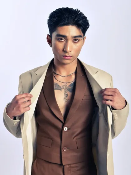 This shot is about the art of layering. The combination of neutral tones creates a sophisticated and stylish menswear look.