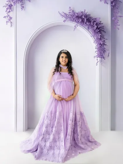 A full-length portrait of a mom-to-be feeling like royalty in a lavender gown, complete with a tiara and a beautiful studio archway. This showcases my themed studio props that add a touch of magic.