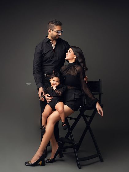 Squad goals! This family portrait is all about modern style and fun. The coordinated black outfits and the little one's happy expression make for a stunning and memorable family photo.
